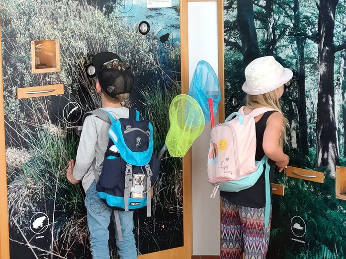 Zwei Kinder entdecken eine Station im Informations- und Bildungszentrum